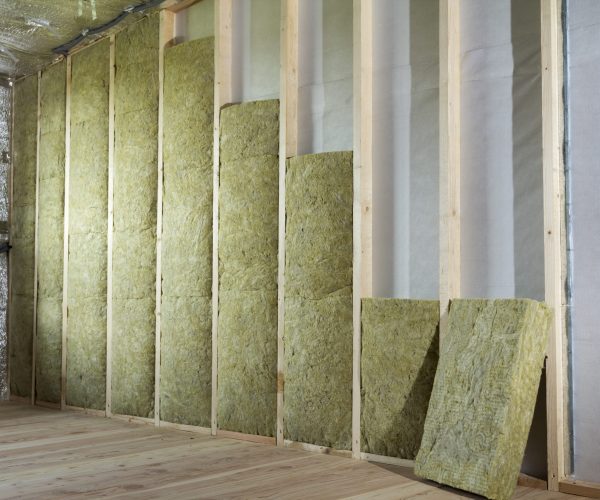 Wooden frame for future walls insulated with rock wool and fiberglass insulation staff for cold barrier. Comfortable warm home, economy, construction and renovation concept.