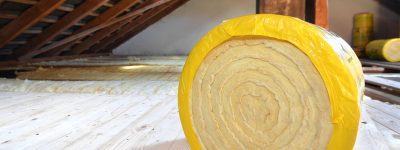 A roll of insulating glass wool on an attic floor