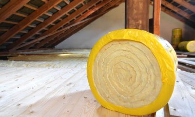 A roll of insulating glass wool on an attic floor