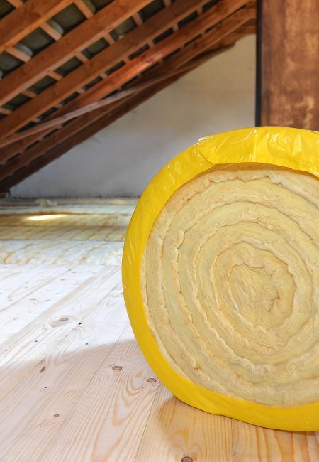 A roll of insulating glass wool on an attic floor
